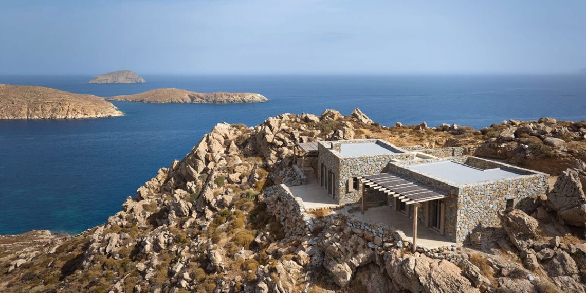 Uncovered stone masonry fuses The residence restored by Co Lab with the rocky land of the Greek island