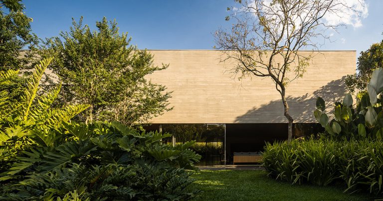 The monolithic concrete home of the MK27 studio is held on the tropical backyard of São Paulo