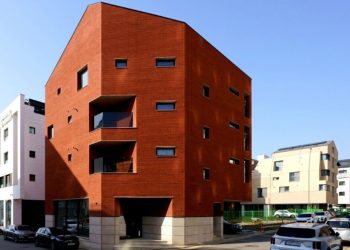 The crimson brick facade wraps the Cornerstone of LKSA housing unit in Korea