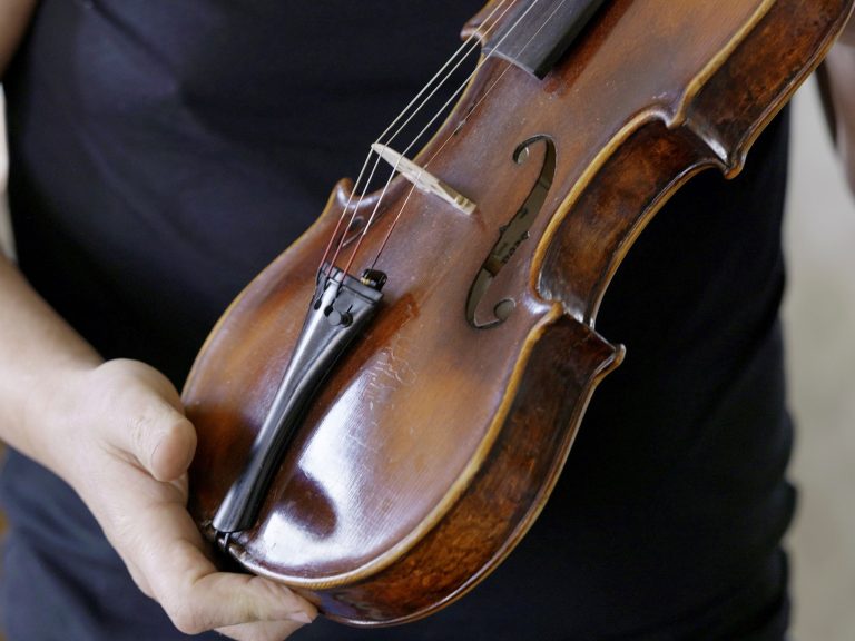A secret be aware hidden in a violin produced within the dachau focus camp tells a survival story