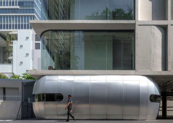 Convex and convex curved concrete panels form the facade of the Aswa constructing