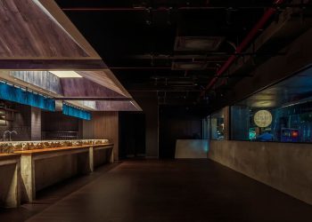 Indigo cloth partitions float above the concrete meters carved within the Rokusho Bar of Intestudio
