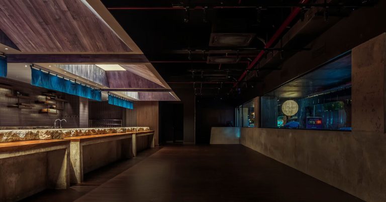 Indigo cloth partitions float above the concrete meters carved within the Rokusho Bar of Intestudio