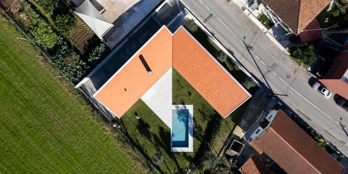 Sculptural chimney pierces the L -shaped home by Martins Structure Workplace in Portugal