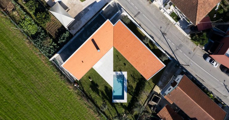 Sculptural chimney pierces the L -shaped home by Martins Structure Workplace in Portugal