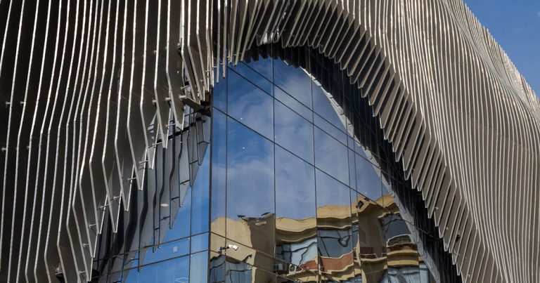 The facade of aluminum curtain wavy drapes over the Ain Shams College Theater in Egypt