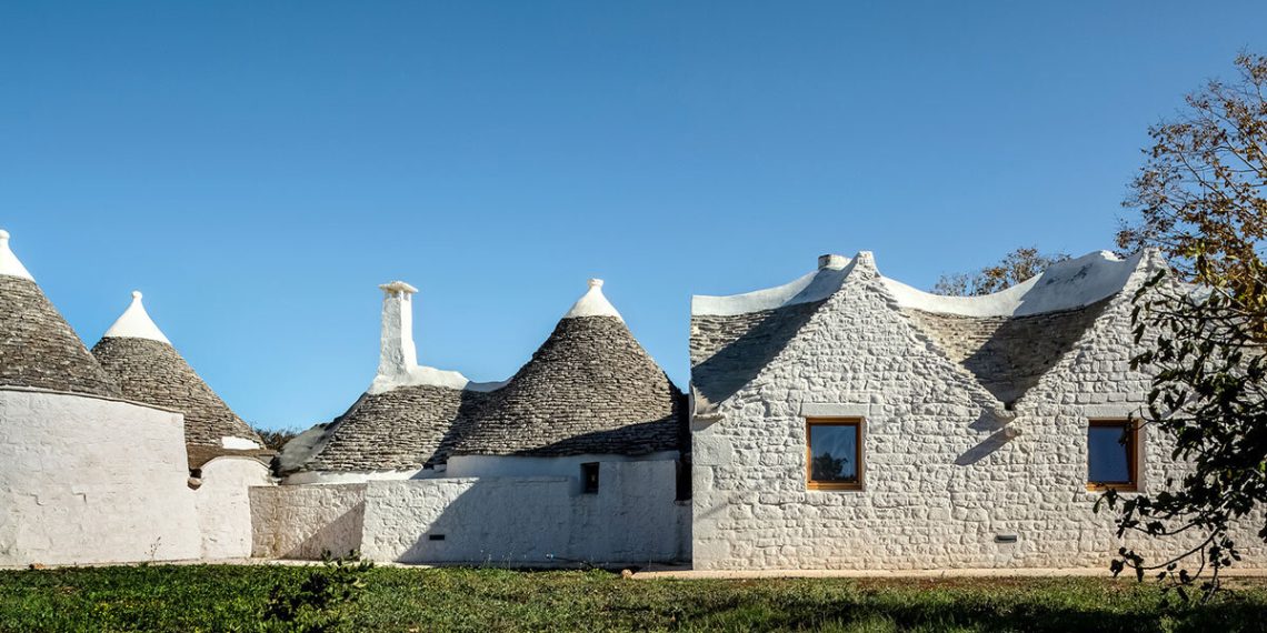 The Risarchitetra’s L -shaped extension completes the stone home in Italy